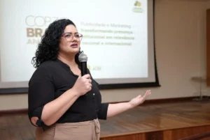 Mão humana e robótica interagindo, simbolizando a colaboração e os desafios da Inteligência Artificial na comunicação profissional.